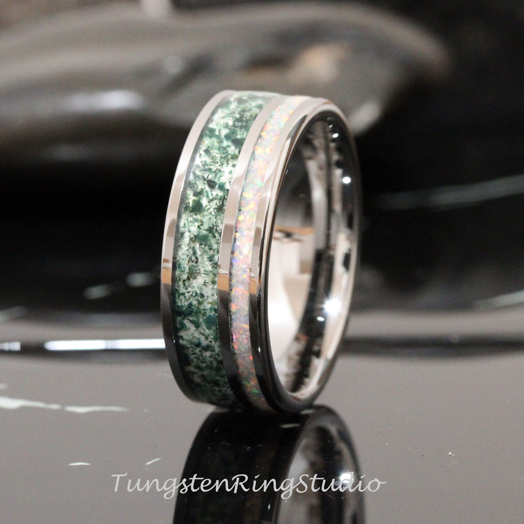 May include: A silver tungsten ring with a green and white inlay. The inlay is a green stone with white flecks and a white opal.