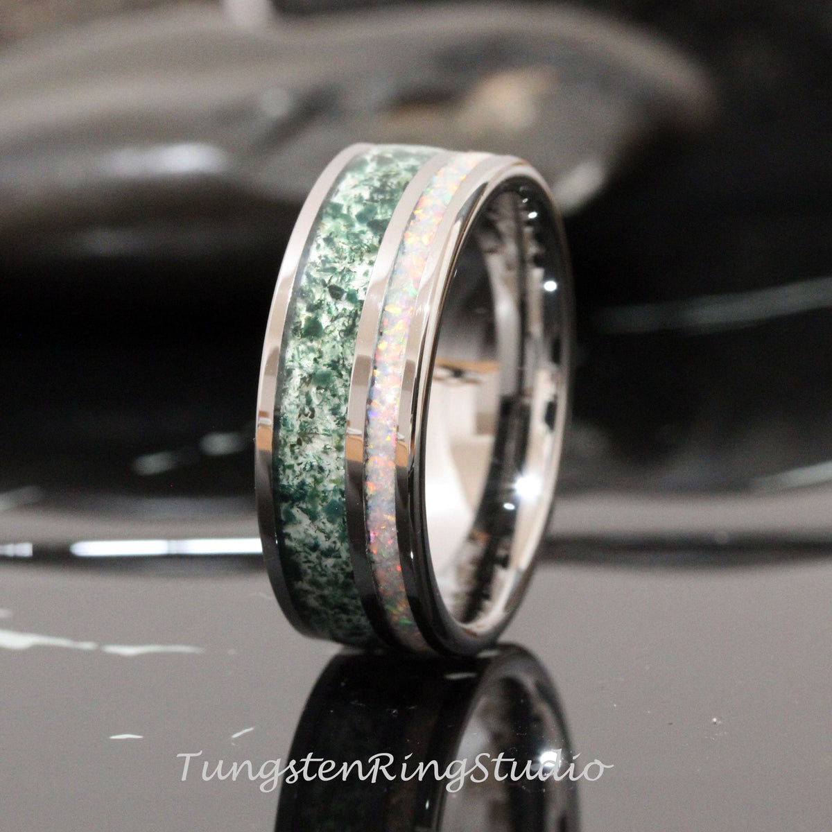 May include: A silver tungsten ring with a green and white inlay. The inlay is a green stone with white flecks and a white opal.
