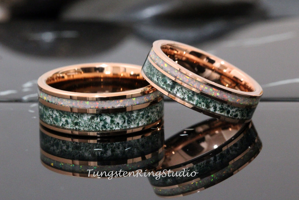 May include: Two tungsten carbide rings with a rose gold finish. The rings have a green and white inlay with a speckled pattern. The rings are stacked on top of each other.