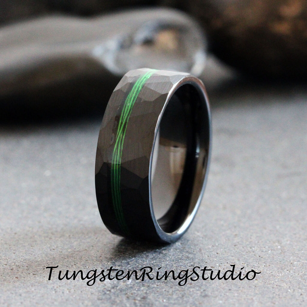 May include: Black tungsten carbide ring with a green inlay and a hammered finish.