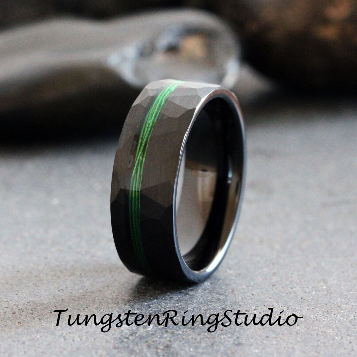 May include: Black tungsten carbide ring with a green inlay and a hammered finish.