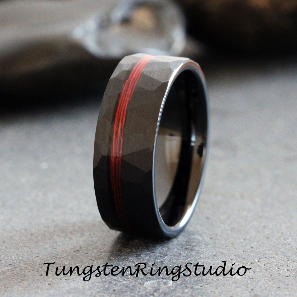 May include: Black tungsten ring with a hammered finish and a red inlay. The ring is approximately 8mm wide.