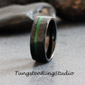 May include: Black tungsten carbide ring with a hammered finish and green inlay. Tungsten Ring Studio.
