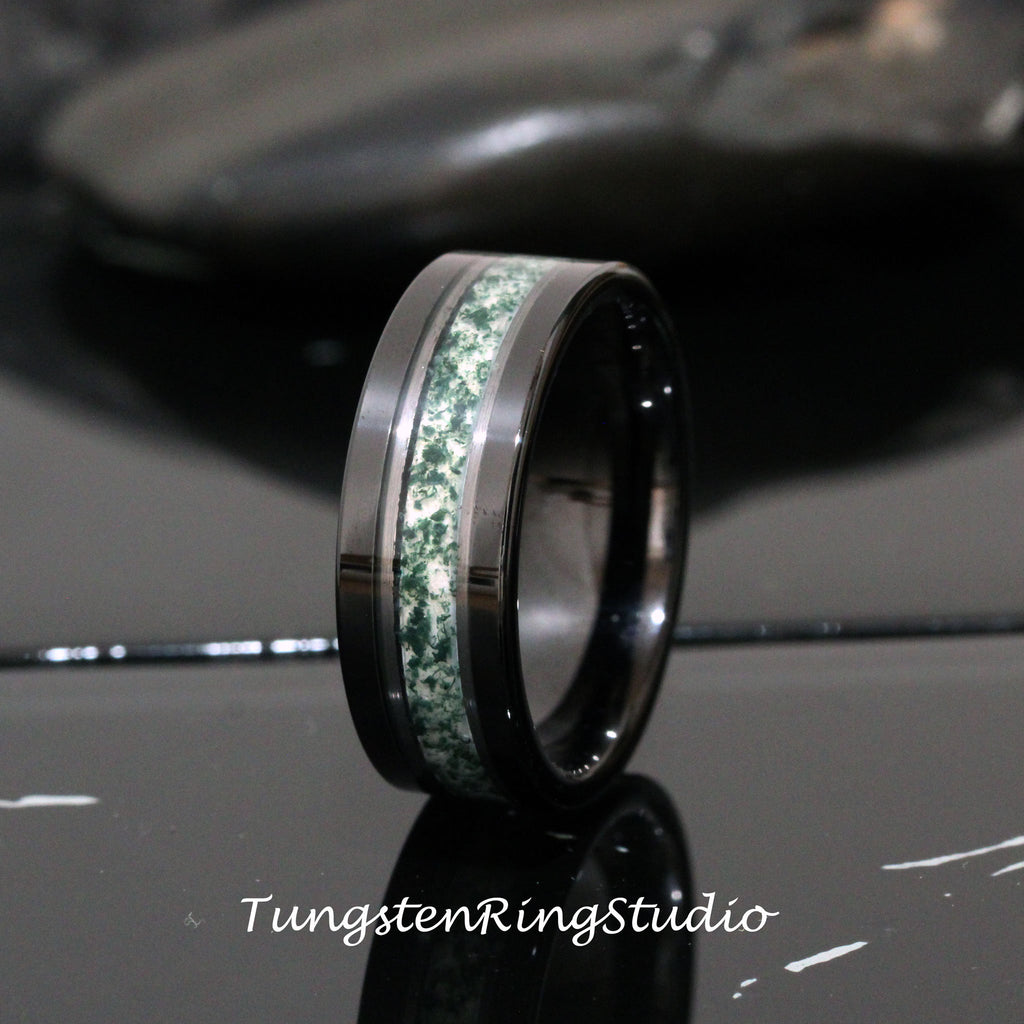 May include: A black tungsten carbide ring with a green and white inlay. The ring has a polished finish.