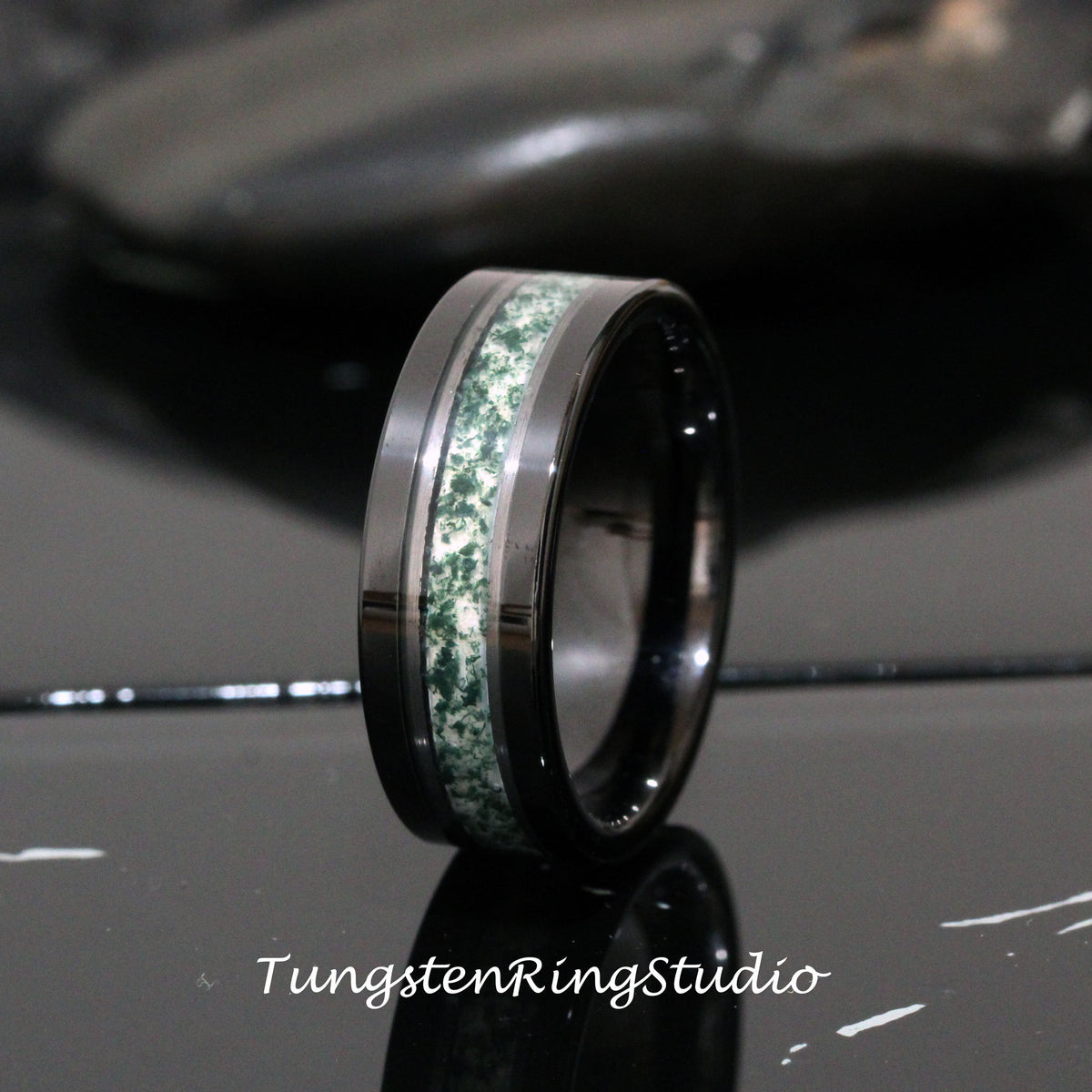 May include: A black tungsten carbide ring with a green and white inlay. The ring has a polished finish.