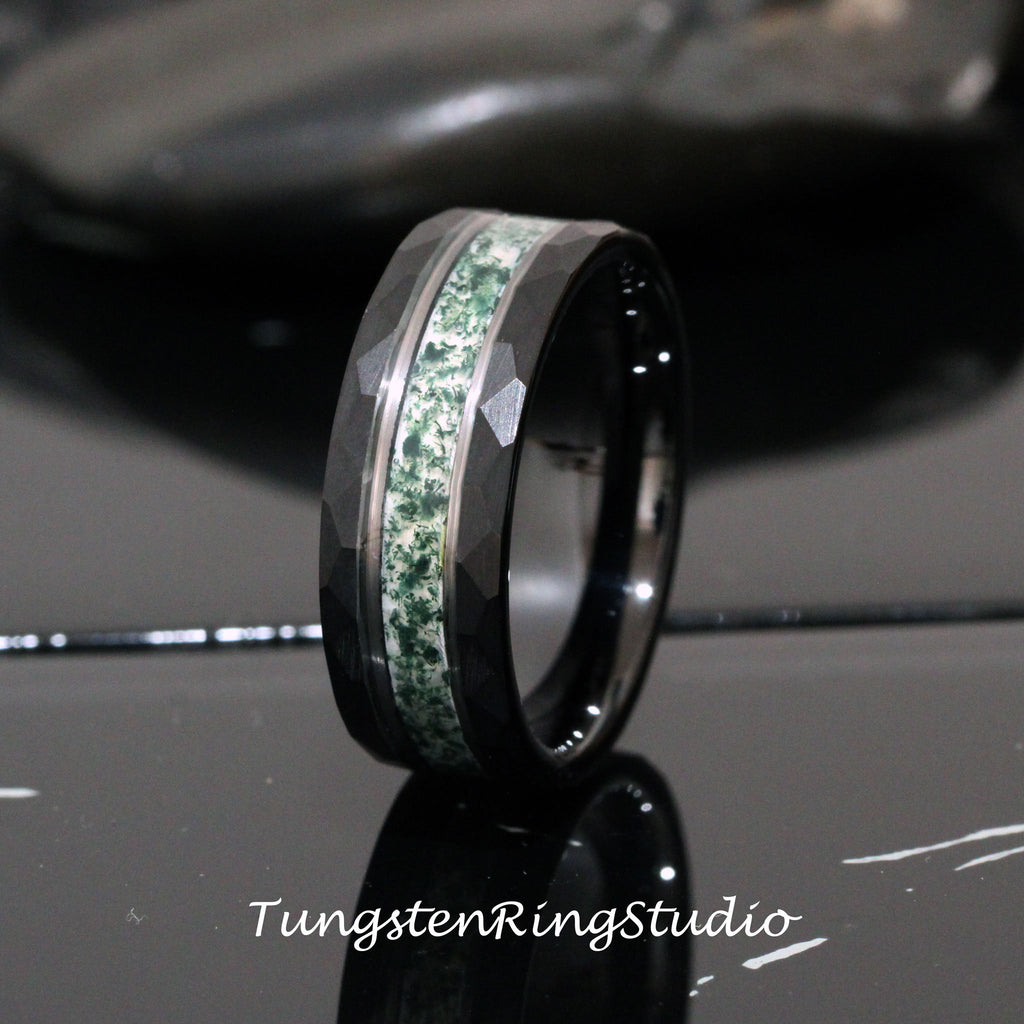 May include: A black tungsten carbide ring with a green and white inlay. The ring has a beveled edge and a brushed finish.