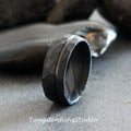 May include: A black tungsten carbide ring with a hammered finish and a polished groove. The ring is a popular choice for men's wedding bands.