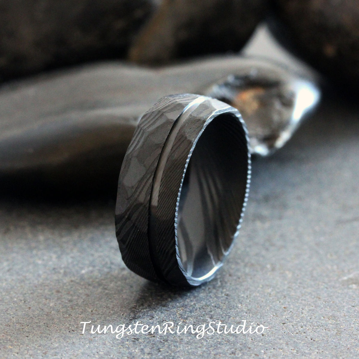 May include: A black tungsten carbide ring with a hammered finish and a polished groove. The ring is a popular choice for men's wedding bands.