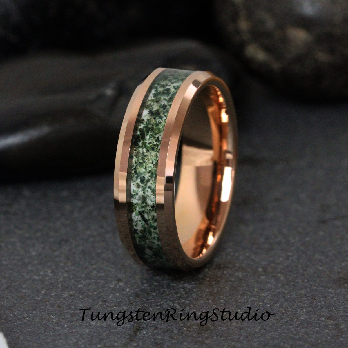 May include: A rose gold tungsten carbide ring with a green and white inlay. The ring has a beveled edge and a polished finish.
