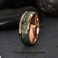 May include: A rose gold tungsten carbide ring with a green and white inlay. The ring has a beveled edge and a polished finish.