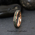 May include: A rose gold tungsten carbide ring with a green and white inlay. The ring is a simple band with a beveled edge.