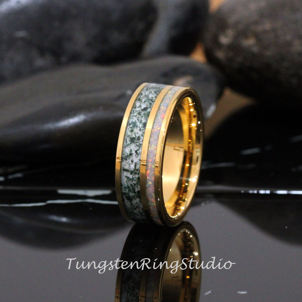 May include: A gold tungsten carbide ring with a green and white inlay. The ring has a polished finish and a beveled edge.