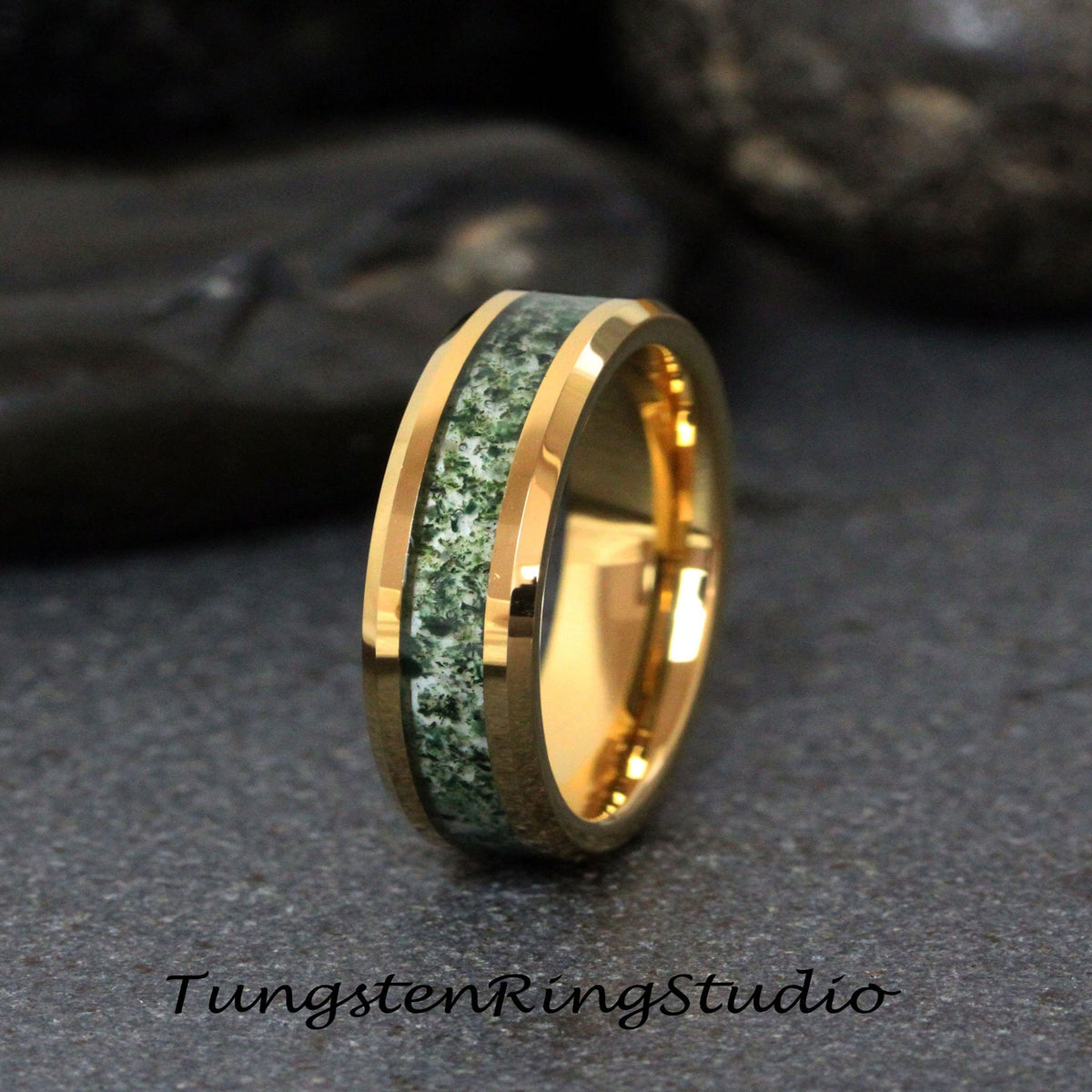 May include: A gold tungsten carbide ring with a green and white inlay. The ring has a beveled edge and a polished finish.