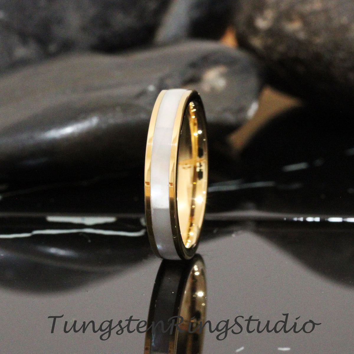 May include: A gold and white tungsten carbide ring with a white inlay. The ring is a simple design with a polished finish.