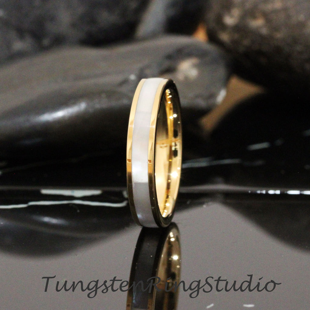 May include: A gold and white tungsten carbide ring with a white inlay. The ring is a simple design with a polished finish.