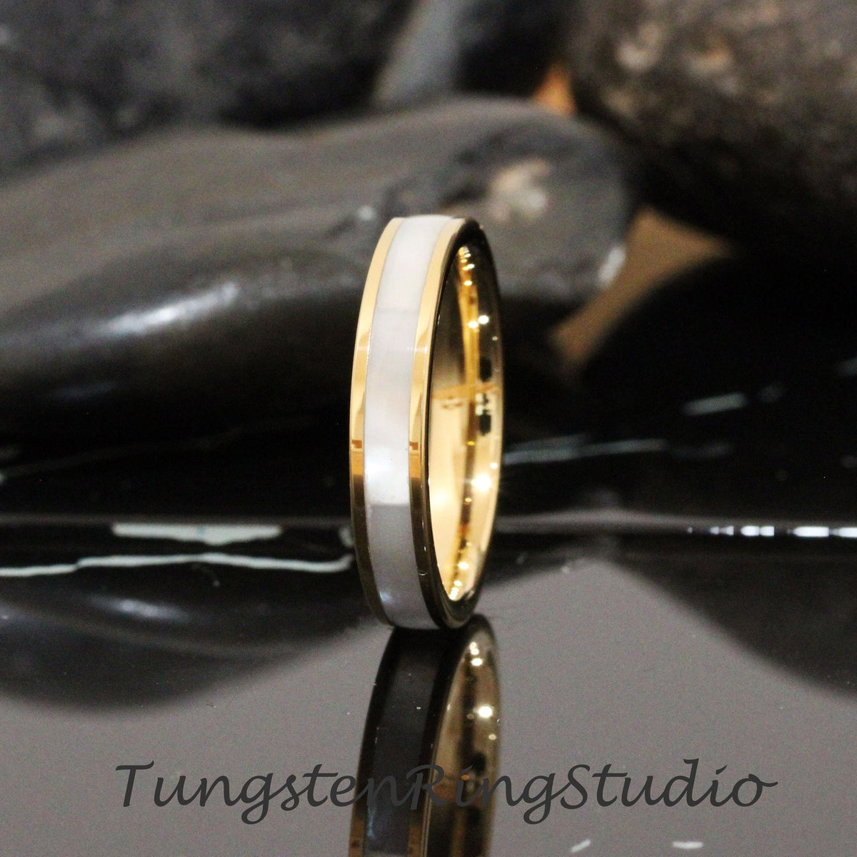 May include: A gold and white tungsten carbide ring with a white inlay. The ring is a simple design with a polished finish.