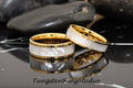 May include: Two gold tungsten carbide rings with a white mother of pearl inlay. The rings are stacked on top of each other.
