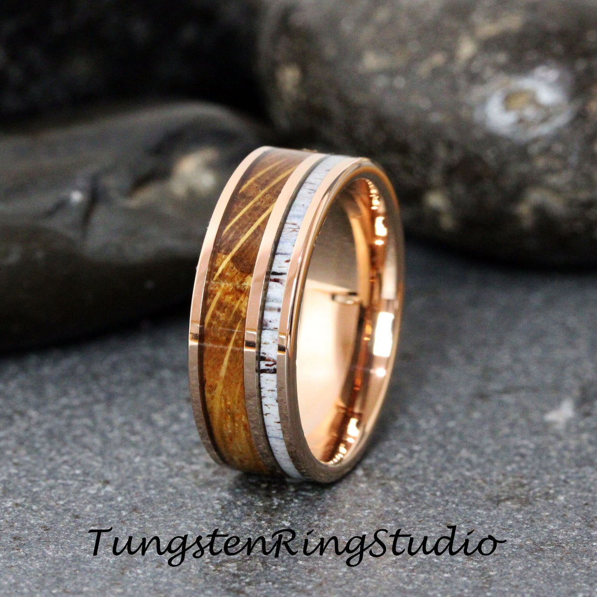 May include: A rose gold tungsten carbide ring with a brown wood inlay and a white antler inlay. The ring is 8mm wide.