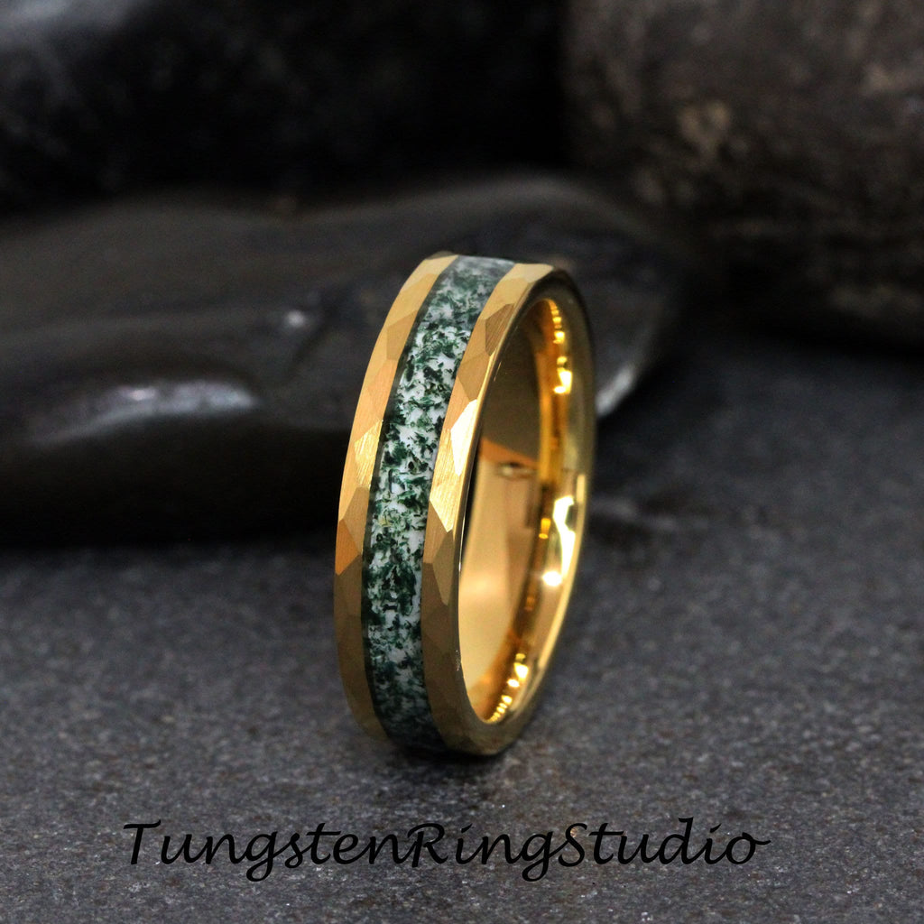 May include: A gold tungsten ring with a green and white inlay. The ring has a beveled edge and a polished finish.