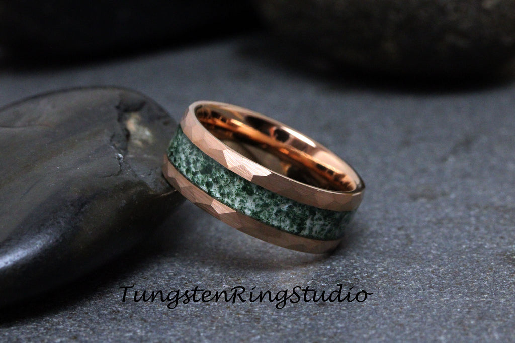 May include: A rose gold tungsten carbide ring with a green and white inlay. The ring has a beveled edge and a polished finish.