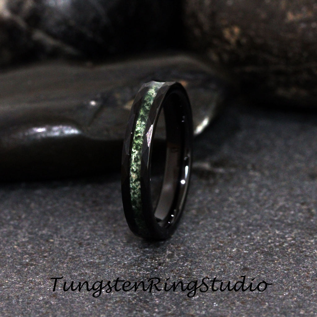 May include: A black tungsten ring with a green inlay. The ring is polished and has a beveled edge.