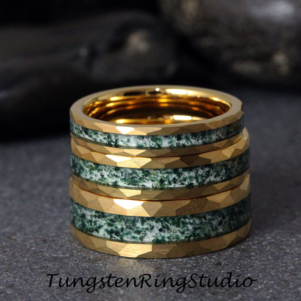 May include: Four gold tungsten carbide rings with a green and white inlay. The rings are stacked on top of each other.