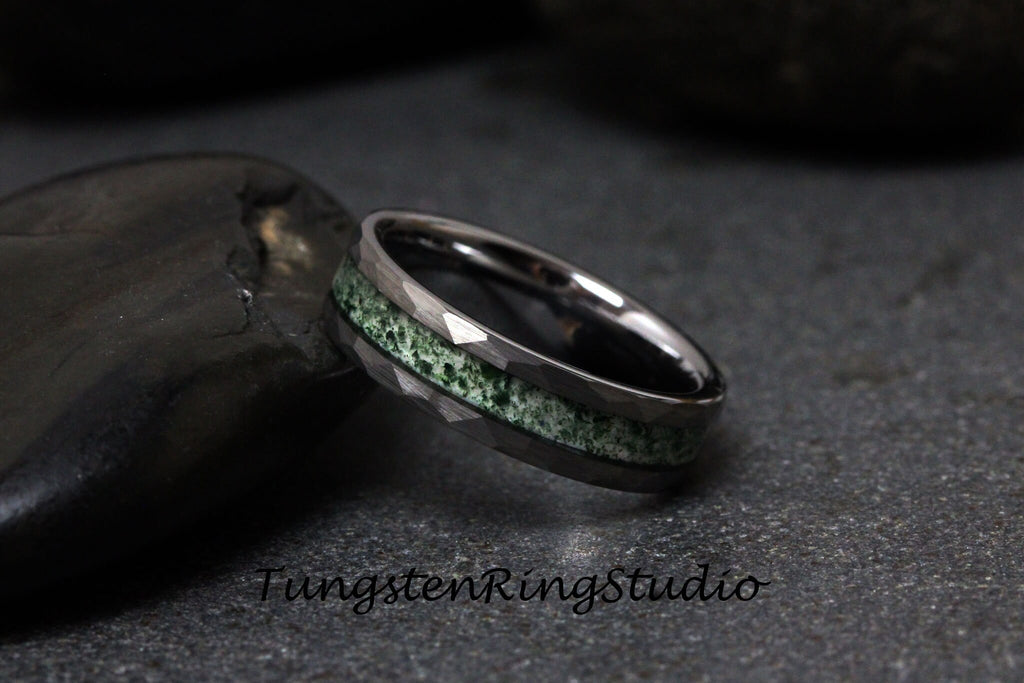 May include: A black tungsten ring with a green inlay. The ring has a beveled edge and a polished finish.