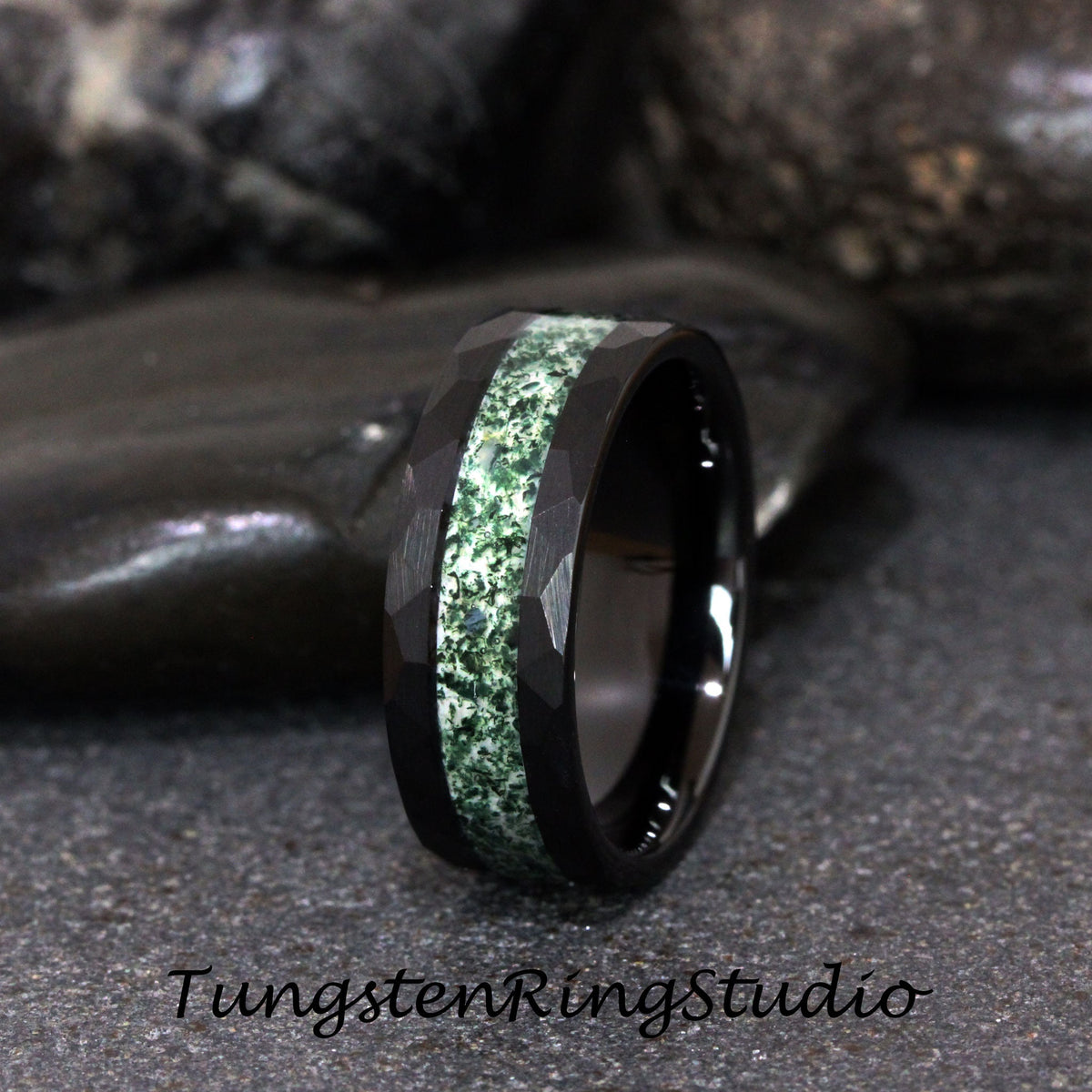 May include: A black tungsten carbide ring with a green and white inlay. The ring has a beveled edge and a brushed finish.