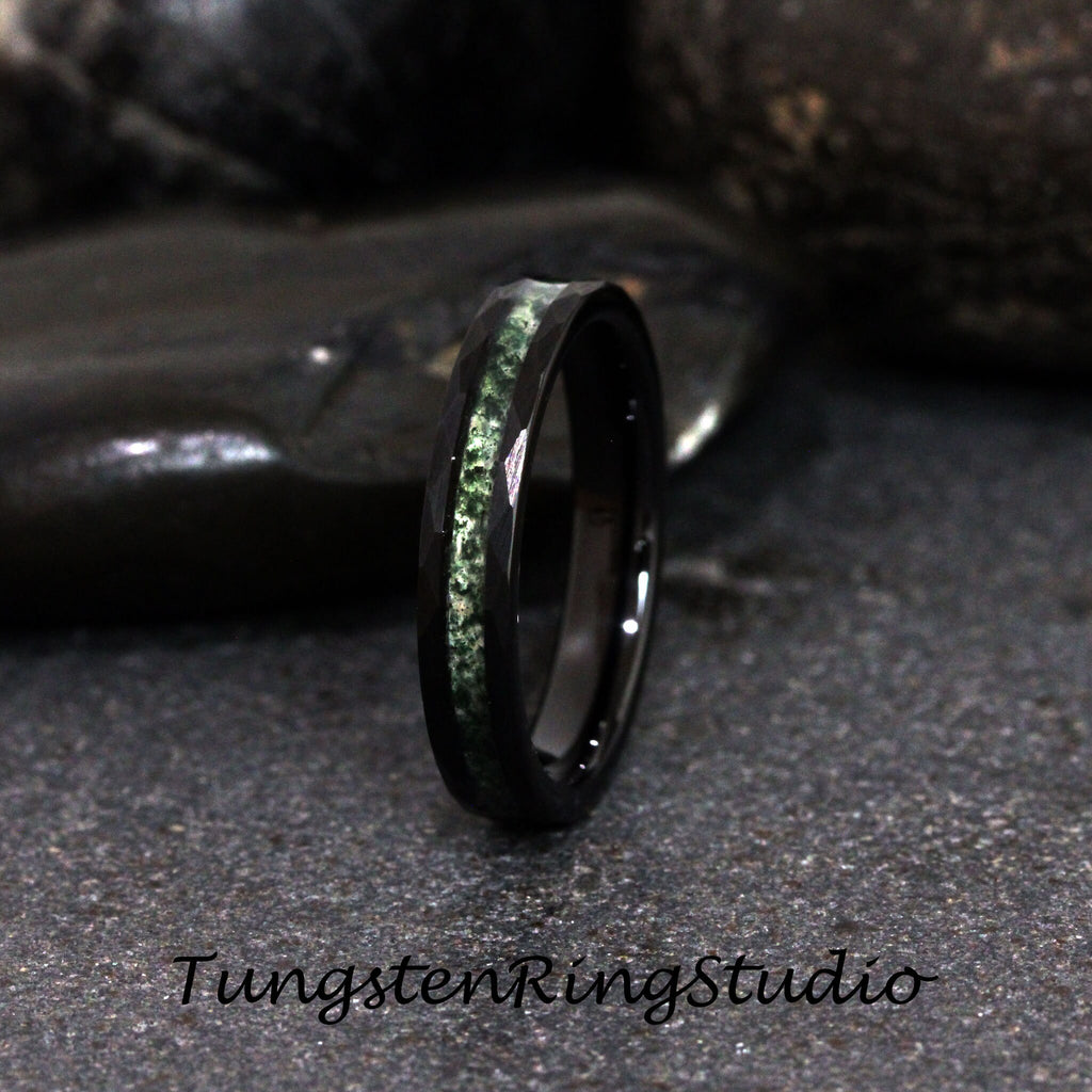 May include: A black tungsten ring with a green inlay. The ring is polished and has a beveled edge.