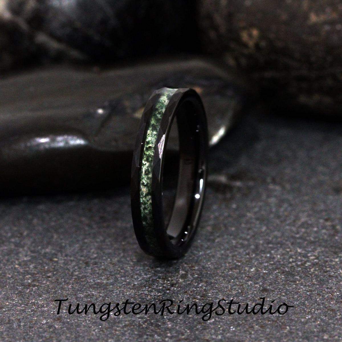May include: A black tungsten ring with a green inlay. The ring is polished and has a beveled edge.