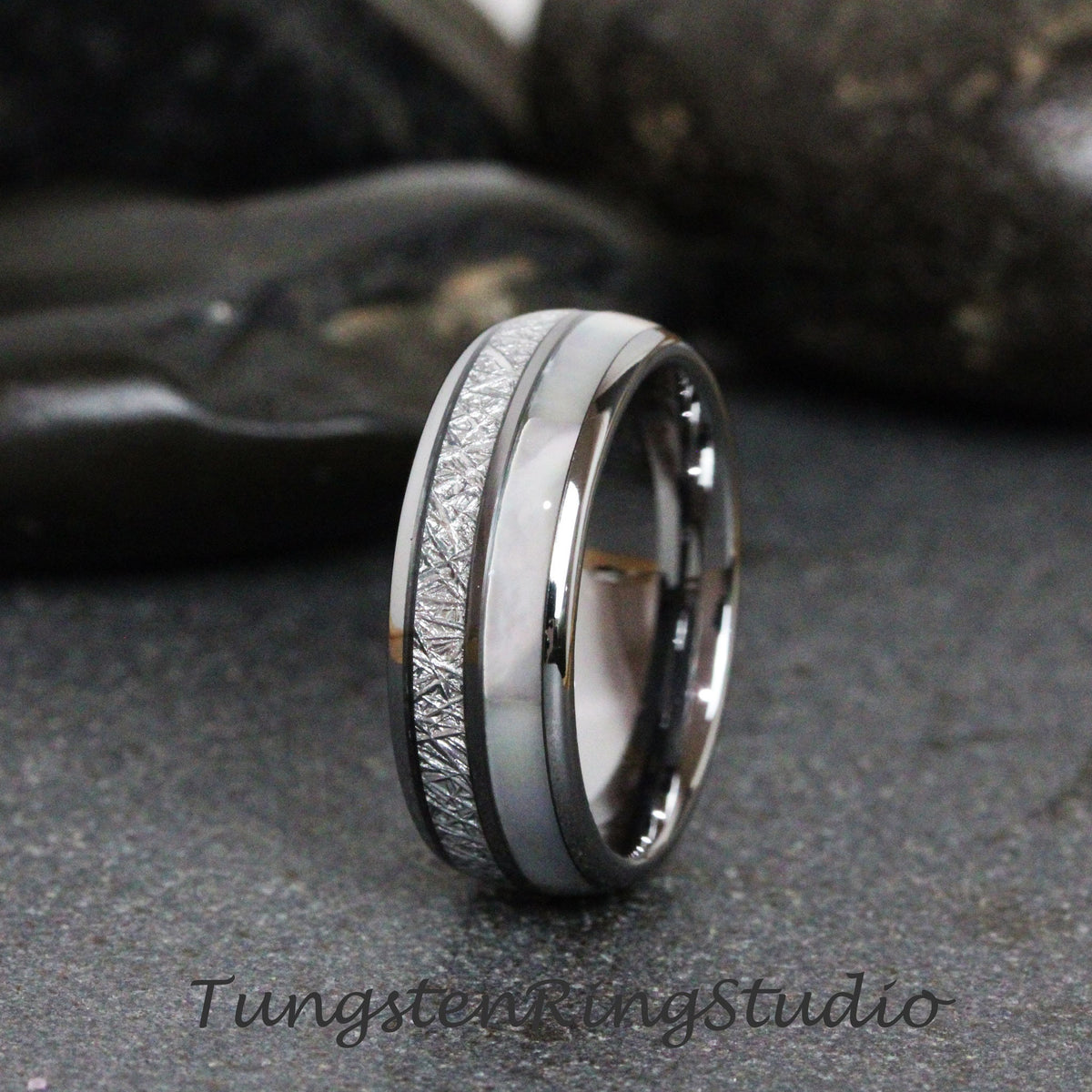 May include: A silver tungsten carbide ring with a white inlay and a textured silver band. The ring is on a gray background.
