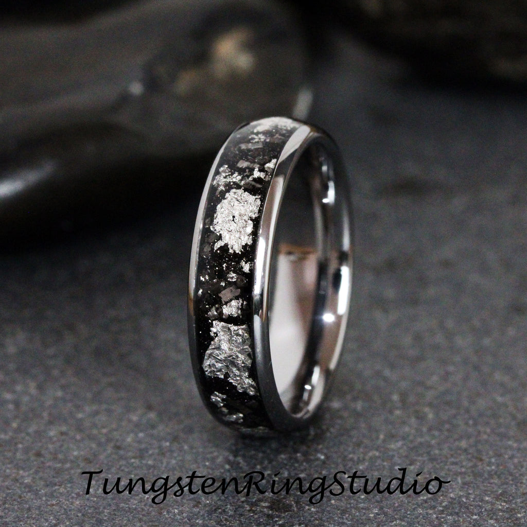 May include: A silver and black tungsten carbide ring with a silver inlay design. The ring is a classic style and has a polished finish.