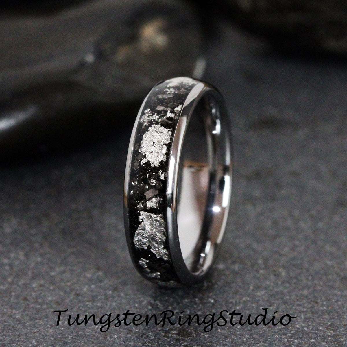 May include: A silver and black tungsten carbide ring with a silver inlay design. The ring is a classic style and has a polished finish.