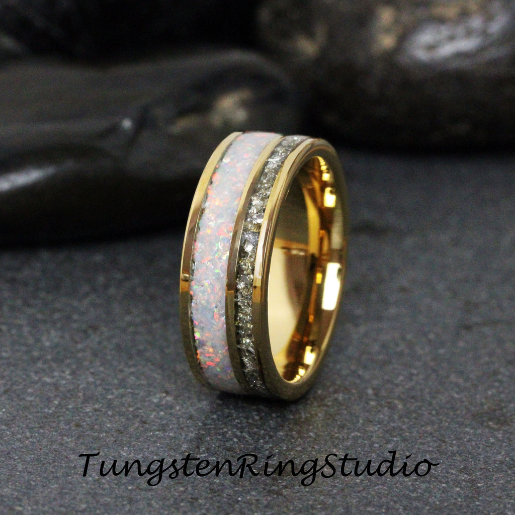 May include: A gold tungsten carbide ring with a white opal inlay and a row of clear cubic zirconia stones.