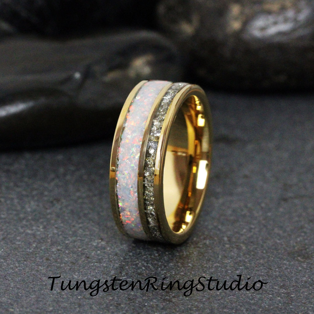 May include: A gold tungsten carbide ring with a white opal inlay and a row of clear cubic zirconia stones.