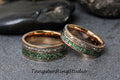 May include: Two rose gold rings with a green stone inlay and a row of clear stones. The rings are on a gray surface. The text "TungstenRingStudio" is at the bottom of the image.