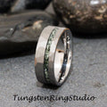 May include: A silver tungsten ring with a hammered finish and a green stone inlay. Tungsten Ring Studio is printed below the ring.