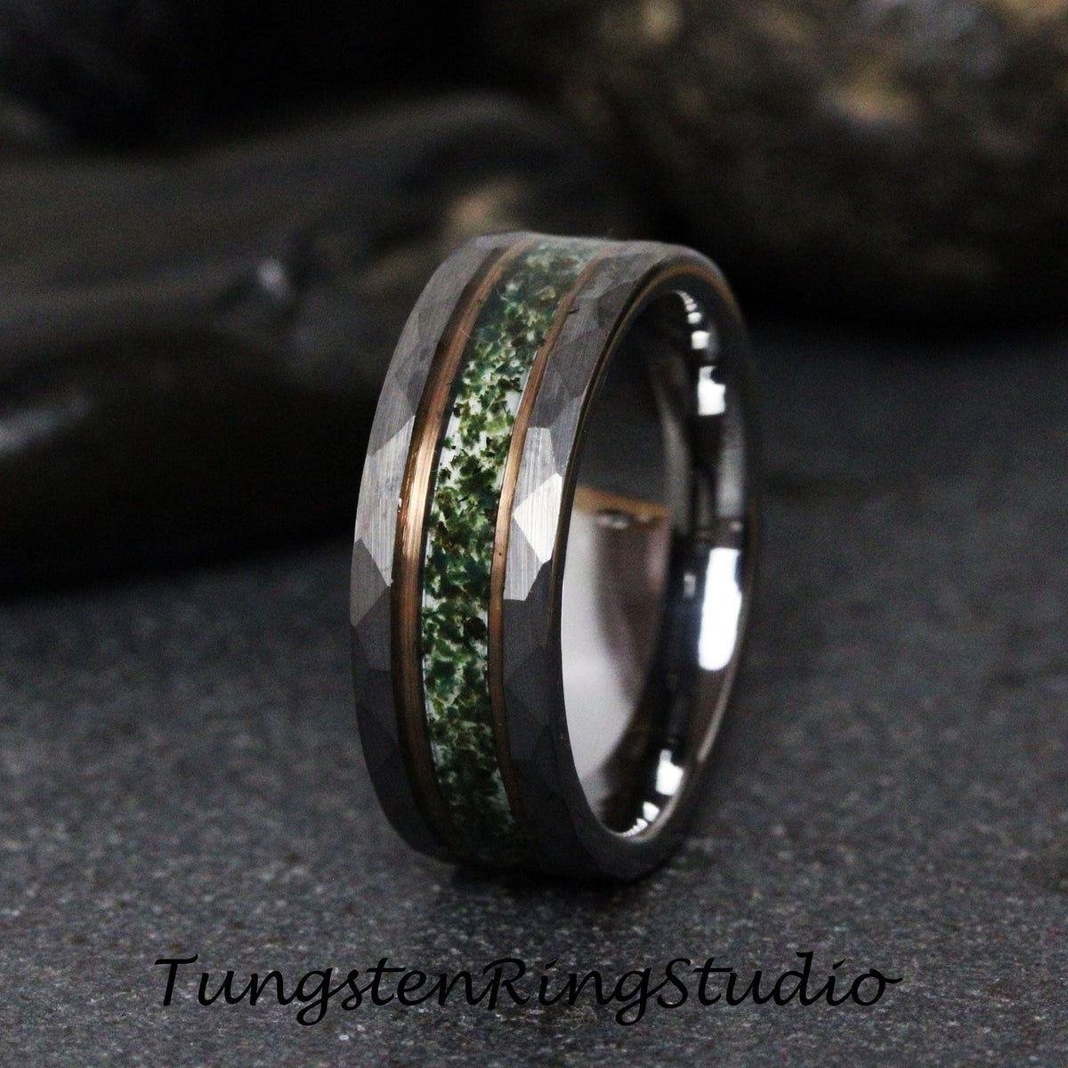 May include: A tungsten carbide ring with a hammered finish and a green and copper inlay. The ring is a dark gray color.