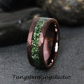 May include: A dark brown tungsten ring with a green and white inlay. The ring has a beveled edge and a hammered finish.