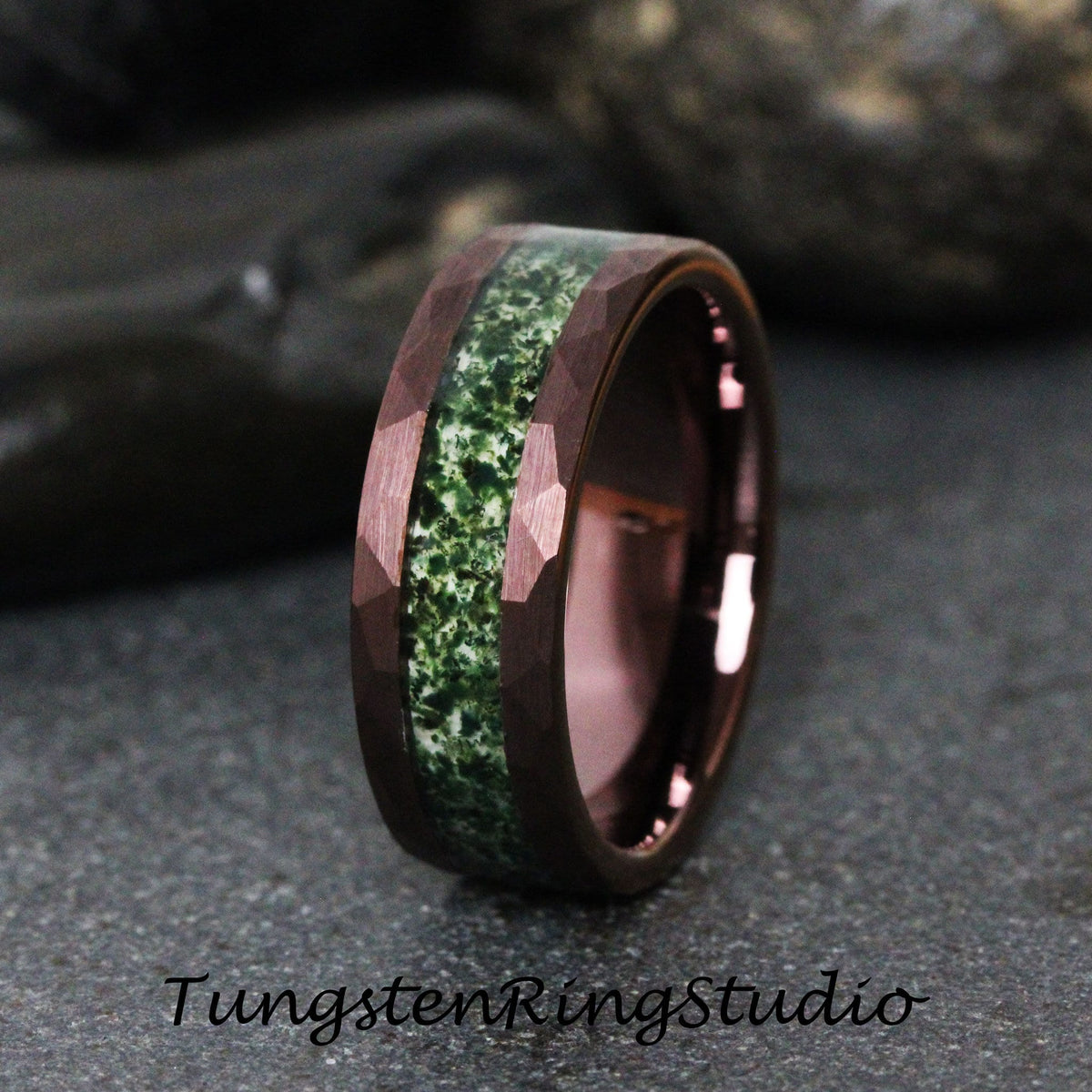 May include: A dark brown tungsten ring with a green and white inlay. The ring has a beveled edge and a hammered finish.