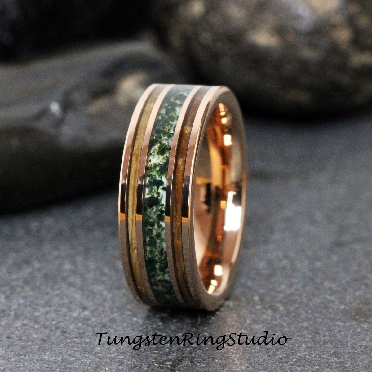 May include: Rose gold ring with a central band of green stone and wood inlays. The ring has a polished finish and the text "TungstenRingStudio" is visible at the bottom.
