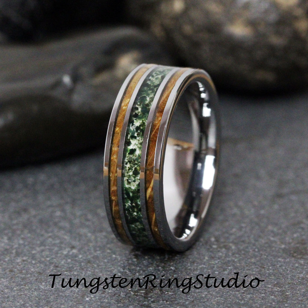 May include: A tungsten carbide ring with a green and brown inlay. The ring has a polished finish and is a popular choice for wedding bands.