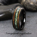 May include: Black tungsten ring with a green and brown inlay. The ring has a polished finish and a beveled edge.