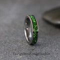 May include: A silver tungsten ring with a green glitter band. The band is made of small green crystals that are embedded in the metal.