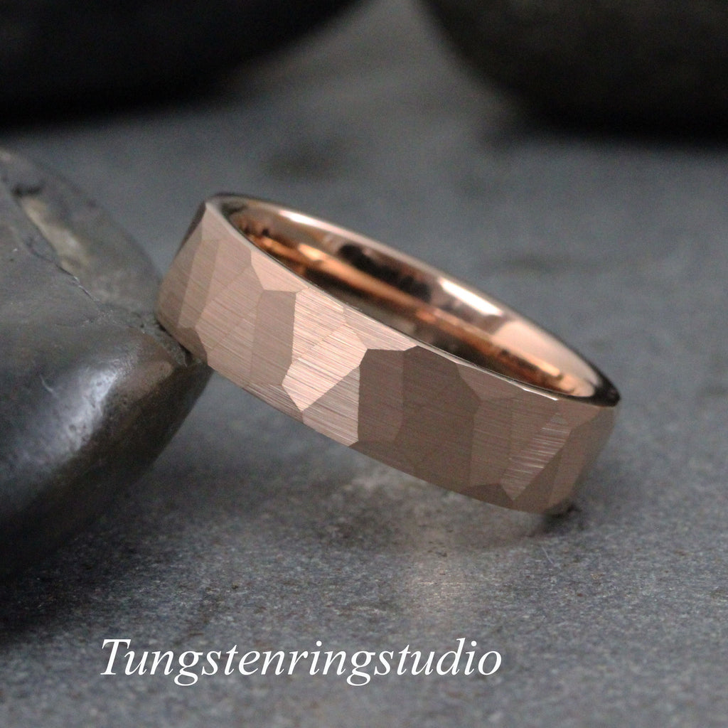 May include: Rose gold tungsten carbide ring with a hammered finish. The ring is a simple band with a slightly rounded edge.