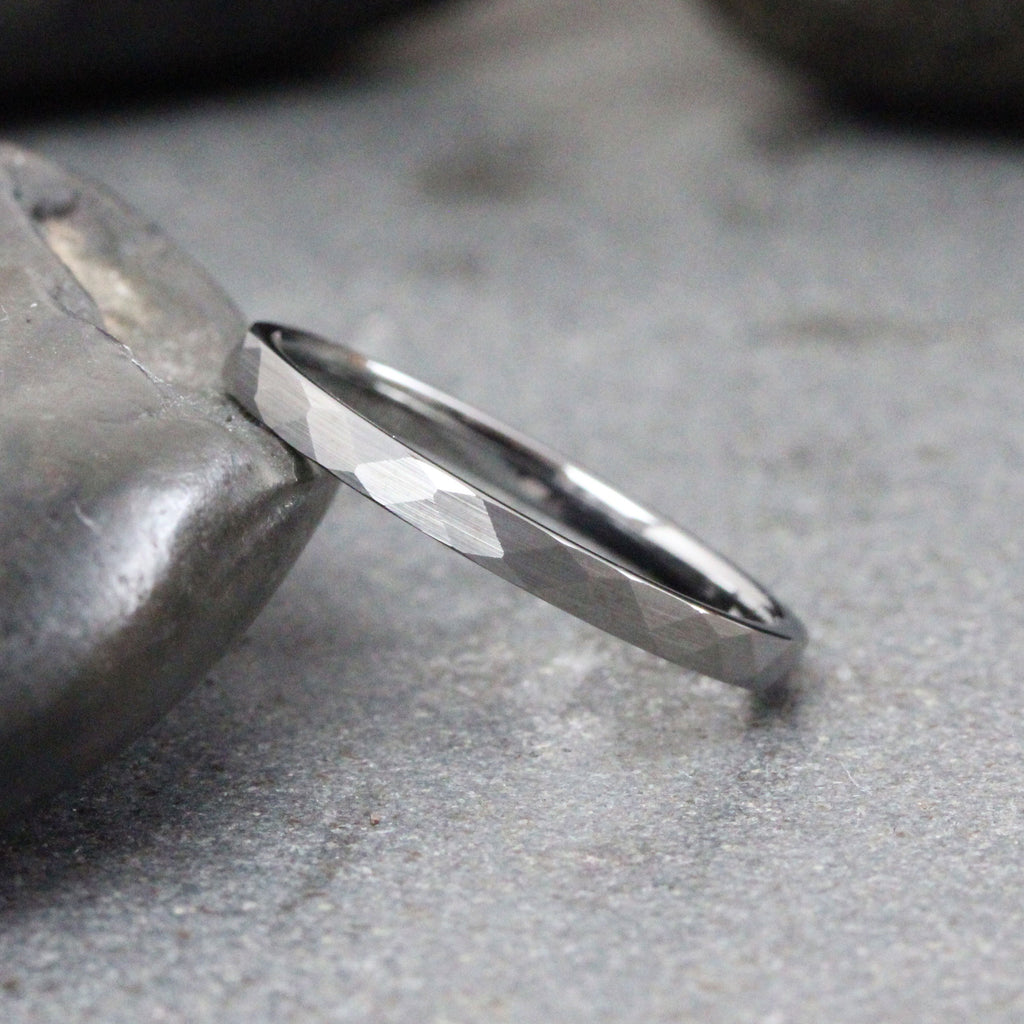 May include: A silver ring with a hammered finish. The ring is thin and has a simple design.