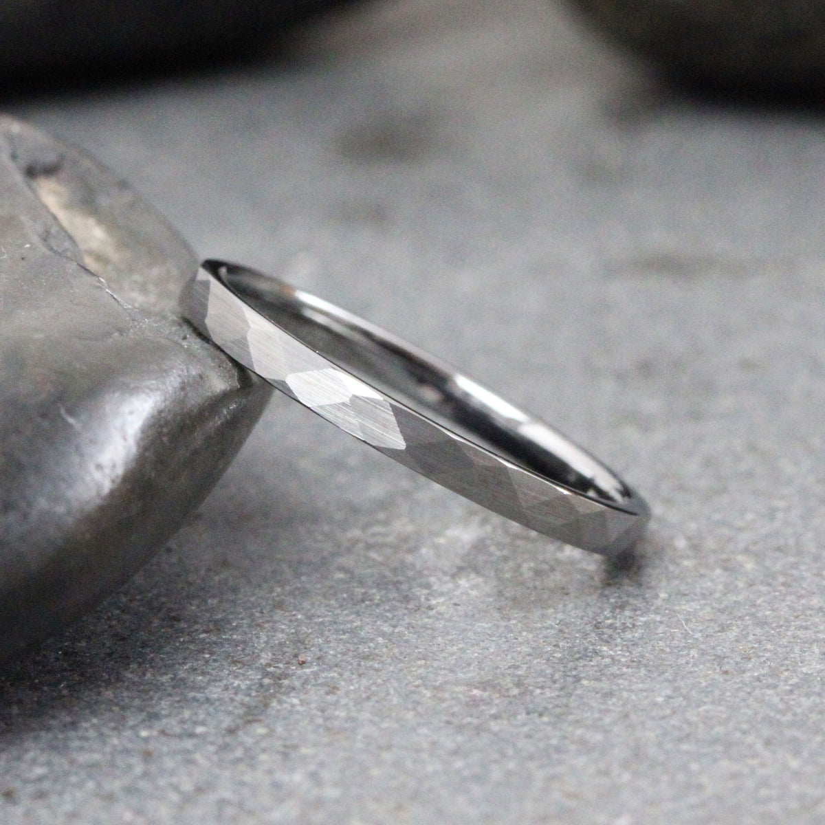 May include: A silver ring with a hammered finish. The ring is thin and has a simple design.