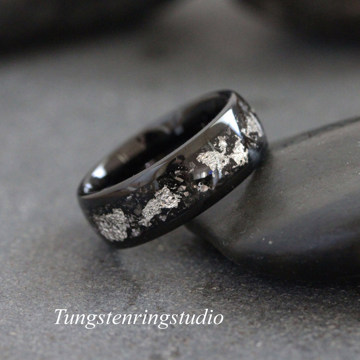May include: Black tungsten carbide ring with a silver inlay design. The ring has a polished finish and a comfortable fit.
