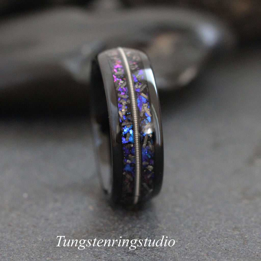 May include: A black tungsten carbide ring with a silver inlay and blue and purple glitter embedded in the band.