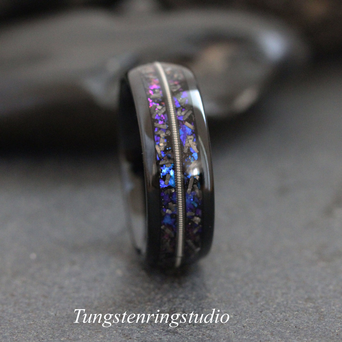 May include: A black tungsten carbide ring with a silver inlay and blue and purple glitter embedded in the band.